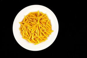 a white plate filled with yellow pasta photo