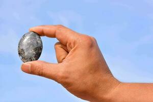 a person holding a rock in their hand photo