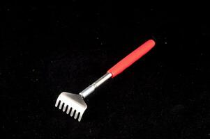 a red plastic fork with a handle on a black surface photo