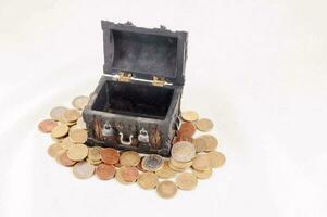 a small wooden chest with coins on top photo