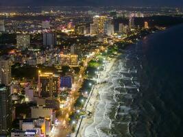 Panoramic coastal Vung Tau view from above, with waves, coastline, streets, coconut trees, Mount Nho in Vietnam behind the statue of Christ the King photo