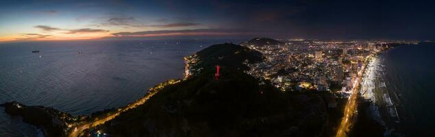 Panoramic coastal Vung Tau view from above, with waves, coastline, streets, coconut trees, Mount Nho in Vietnam behind the statue of Christ the King photo