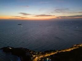 Panoramic coastal Vung Tau view from above, with waves, coastline, streets, coconut trees, Mount Nho in Vietnam behind the statue of Christ the King photo