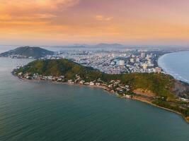 Panoramic coastal Vung Tau view from above, with waves, coastline, streets, coconut trees, Mount Nho in Vietnam behind the statue of Christ the King photo