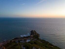 Panoramic coastal Vung Tau view from above, with waves, coastline, streets, coconut trees, Mount Nho in Vietnam behind the statue of Christ the King photo