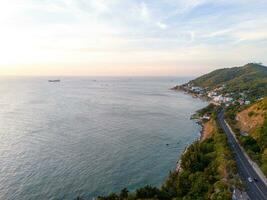 Panoramic coastal Vung Tau view from above, with waves, coastline, streets, coconut trees, Mount Nho in Vietnam behind the statue of Christ the King photo