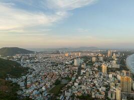 Panoramic coastal Vung Tau view from above, with waves, coastline, streets, coconut trees, Mount Nho in Vietnam behind the statue of Christ the King photo