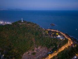 Panoramic coastal Vung Tau view from above, with waves, coastline, streets, coconut trees, Mount Nho in Vietnam behind the statue of Christ the King photo