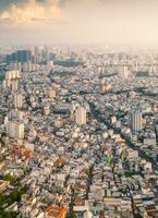 Panoramic view of Saigon, Vietnam from above at Ho Chi Minh City's central business district. Cityscape and many buildings, local houses, bridges, rivers photo