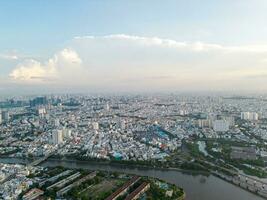 Panoramic view of Saigon, Vietnam from above at Ho Chi Minh City's central business district. Cityscape and many buildings, local houses, bridges, rivers photo