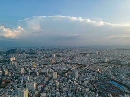 Panoramic view of Saigon, Vietnam from above at Ho Chi Minh City's central business district. Cityscape and many buildings, local houses, bridges, rivers photo