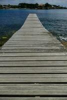 a wooden pier stretching out into the ocean photo