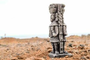 a statue of a man standing on top of a dirt field photo