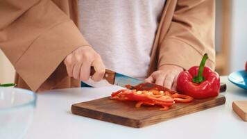 Wife hands close up slicing pepper on wooden cutting board in kitchen. Cooking preparing healthy organic food happy together lifestyle. Cheerful meal in family with vegetables photo