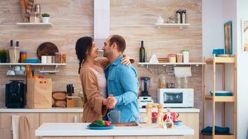 Tender couple dancing in kitchen and fresh vegetables on table. Cheerful happy young family together dance. Fun love affection romance leisure romantic music for enjoynment photo