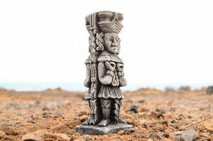 a statue of a man standing on top of a rock photo