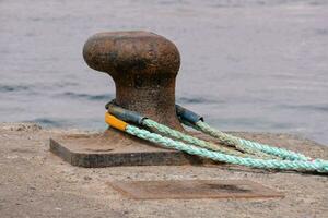 a rope and a metal anchor on a dock photo