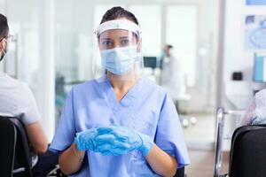 Medical staff in waiting area of hospital wearing surgical face mask as safety precaution against coronavirus global pandemic., Physician, epidemic, care, surgical, corridor. photo