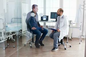 Doctor consulting young man in hospital examination room wearing white coat. Stethoscope, appointment, diagnosis, specialist. photo