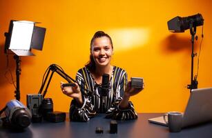 Famous vlogger smiling while recording video about professional accumulators. Presenting review studio portable testing modern batteries li-lion accessory device modern lighting technology. photo