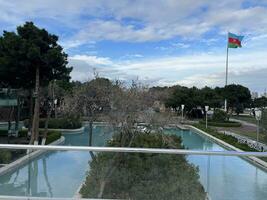 AI generated park with pool and azerbaijan flag waving in cloudy weather photo