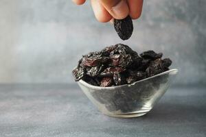 hand pick black raisin from a bowl photo