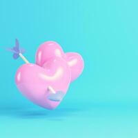 Pink two heart pierced by cupid arrow on bright blue background in pastel colors photo