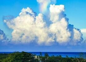 Beautiful and rare rainbow in cloudy sky blue background Mexico. photo