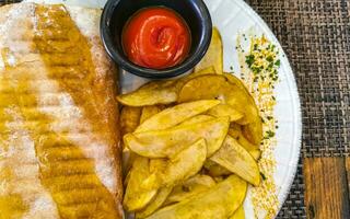 Baguette sandwich toast bread with chicken tomato salad potatoes fries. photo