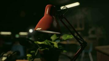 A red lamp sitting on top of a table next to a potted plant video