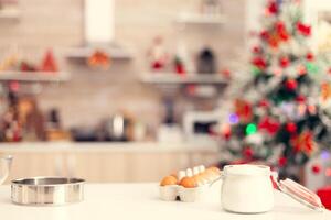 ingredientes para preparación de delicioso galletas en mesa en vacío habitación. cocina en Navidad día con nadie en el habitación decorado con Navidad árbol y guirnaldas foto