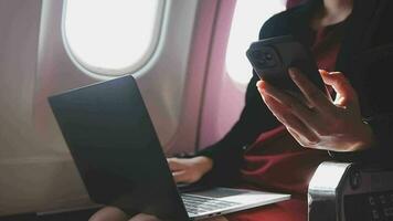 Asian young woman using laptop sitting near windows at first class on airplane during flight,Traveling and Business concept video