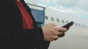 mujer joven asiática que usa una computadora portátil sentada cerca de las ventanas en primera clase en un avión durante el vuelo, los viajes y el concepto de negocios video