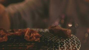 Party for barbecue japanese style, yakiniku. Meats are being cooked on stove in a japanese video