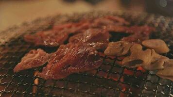 Party for barbecue japanese style, yakiniku. Meats are being cooked on stove in a japanese video