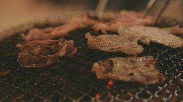 Party for barbecue japanese style, yakiniku. Meats are being cooked on stove in a japanese video