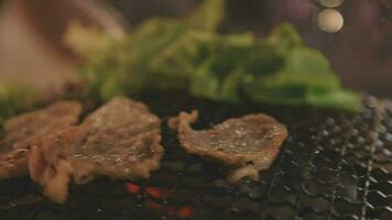 Party for barbecue japanese style, yakiniku. Meats are being cooked on stove in a japanese video