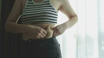 Fette Frau, dicker Bauch, mollige, fettleibige Frauenhand, die übermäßiges Bauchfett mit Maßband hält, Frauendiät-Lifestyle-Konzept video