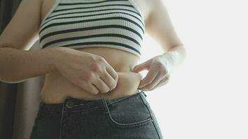 mulher gorda, barriga gorda, gordinha, mão de mulher obesa segurando gordura excessiva da barriga com fita métrica, conceito de estilo de vida de dieta de mulher video