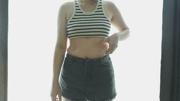 mujer gorda, barriga gorda, gordita, mujer obesa mano sosteniendo grasa abdominal excesiva con cinta métrica, concepto de estilo de vida de dieta de mujer video