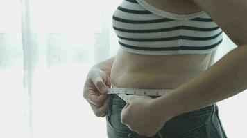 mujer gorda, barriga gorda, gordita, mujer obesa mano sosteniendo grasa abdominal excesiva con cinta métrica, concepto de estilo de vida de dieta de mujer video