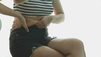 grosse femme, gros ventre, joufflu, main de femme obèse tenant la graisse du ventre excessive avec ruban à mesurer, concept de mode de vie de régime alimentaire femme video