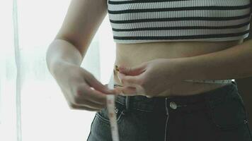 mujer gorda, barriga gorda, gordita, mujer obesa mano sosteniendo grasa abdominal excesiva con cinta métrica, concepto de estilo de vida de dieta de mujer video