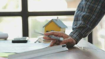 mains de architecte ou ingénieur travail sur plan réunion pour projet travail avec partenaire sur modèle bâtiment et ingénierie outils dans travail placer, construction et structure concept. video