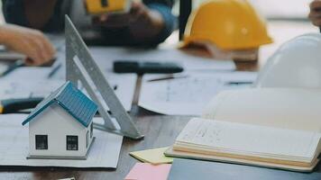 mani di architetto o ingegnere Lavorando su planimetria incontro per progetto Lavorando con compagno su modello edificio e ingegneria utensili nel Lavorando luogo, costruzione e struttura concetto. video