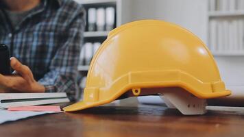 mani di architetto o ingegnere Lavorando su planimetria incontro per progetto Lavorando con compagno su modello edificio e ingegneria utensili nel Lavorando luogo, costruzione e struttura concetto. video