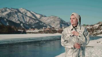 contento mujer camina cerca el río en el tierras altas en invierno. video