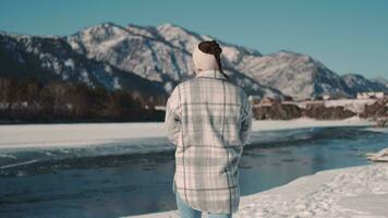 un' donna va per il fiume nel inverno nel il altopiani. video