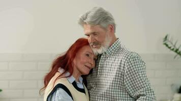 amoroso Senior casal 60-70 anos velho lento dança às casa dentro a cozinha. video