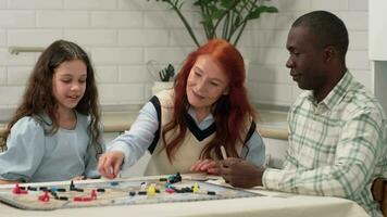 multi etnisch familie van verschillend leeftijd generaties zijn spelen een bord spel het werpen Dobbelsteen Aan de tafel Bij huis zittend Bij de tafel. video